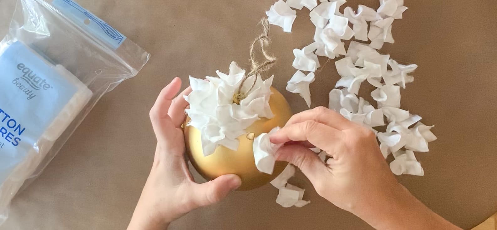 Gluing cotton shapes to ornament.