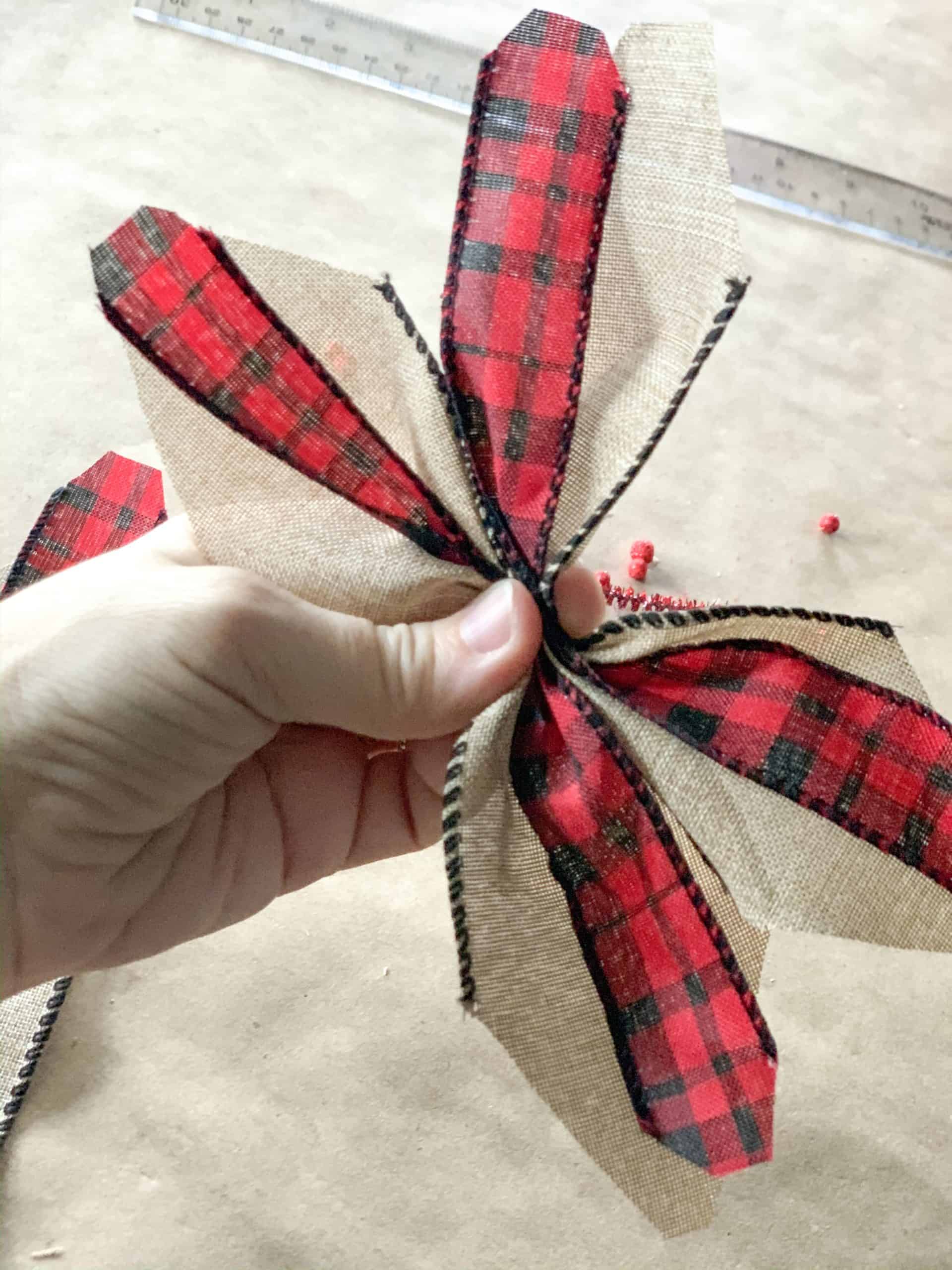 Pinching center of ribbons in accordion type fold.