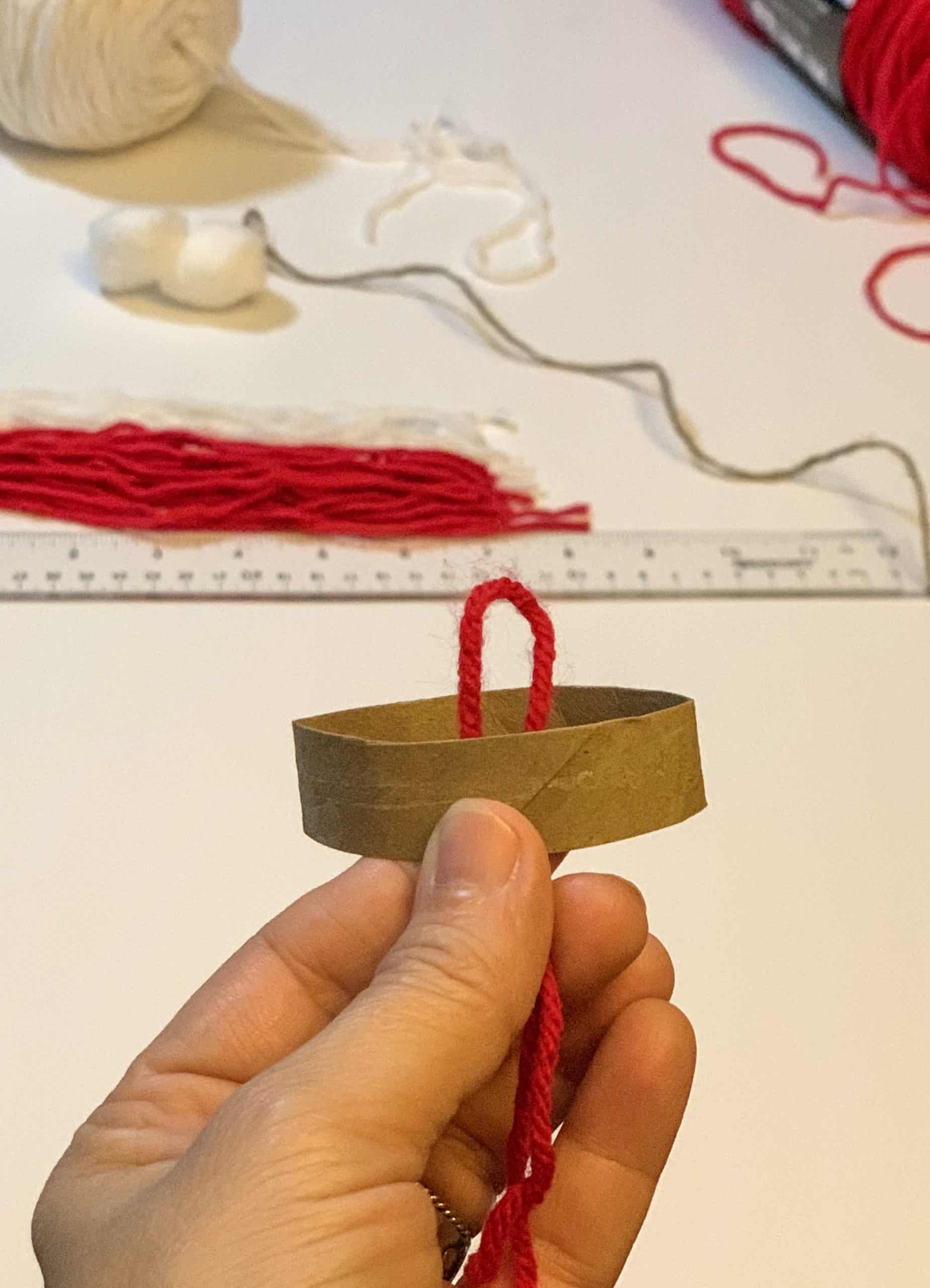 looping yarn through cardboard circle.