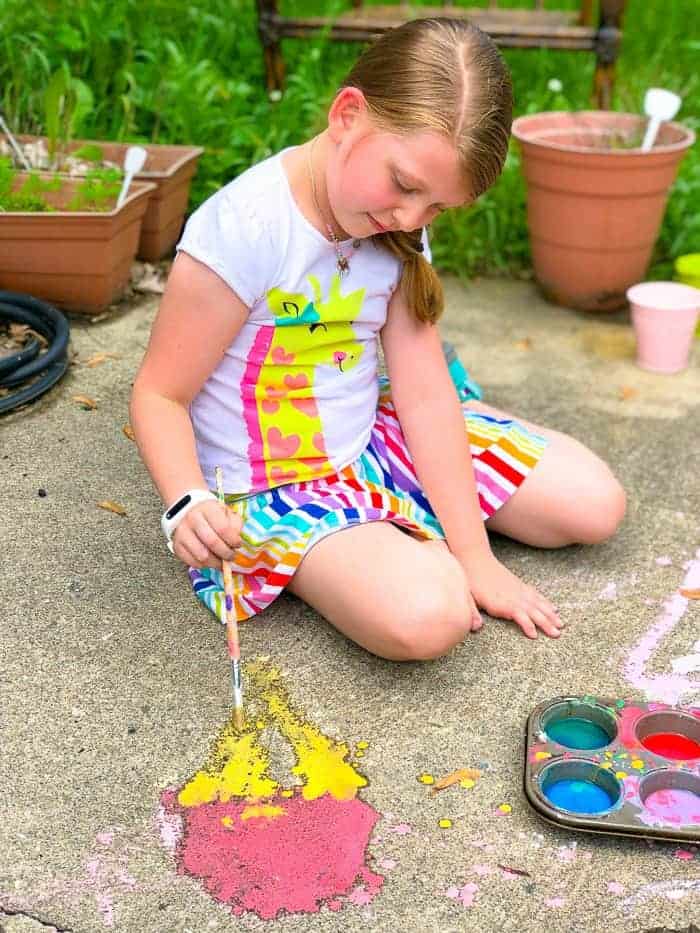 Young girl painting with diy magic sidewalk chalk.