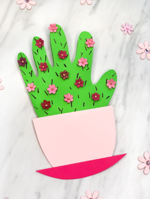 Handprint craft green cactus in pink flower pot.