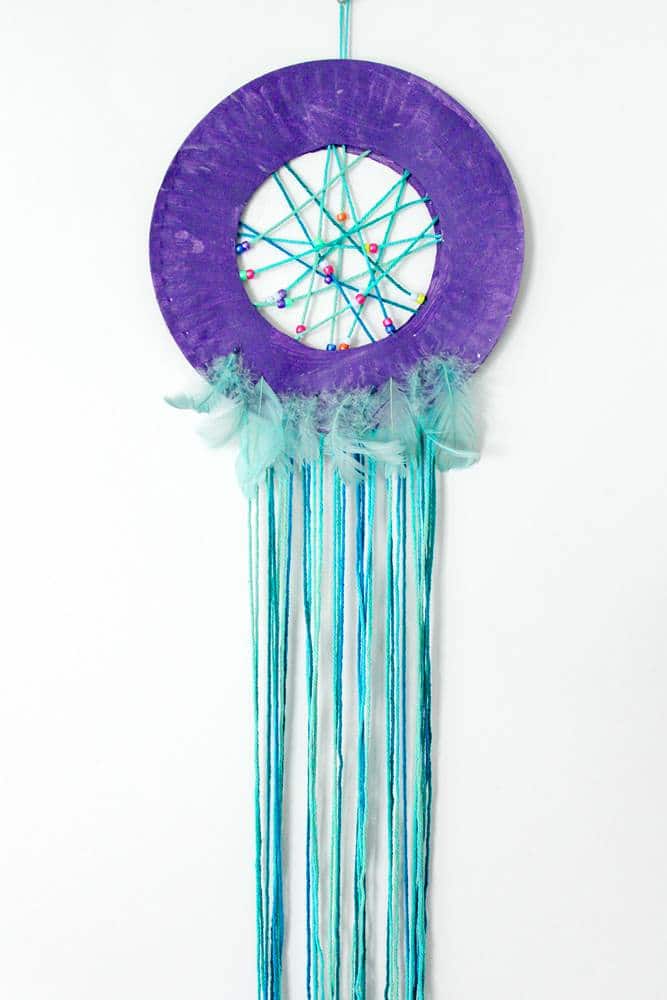 Paper plate dream catcher with beads and feathers craft project.