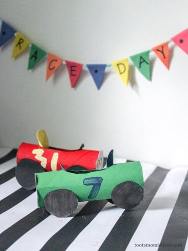 A red and a green toilet paper roll race cars.