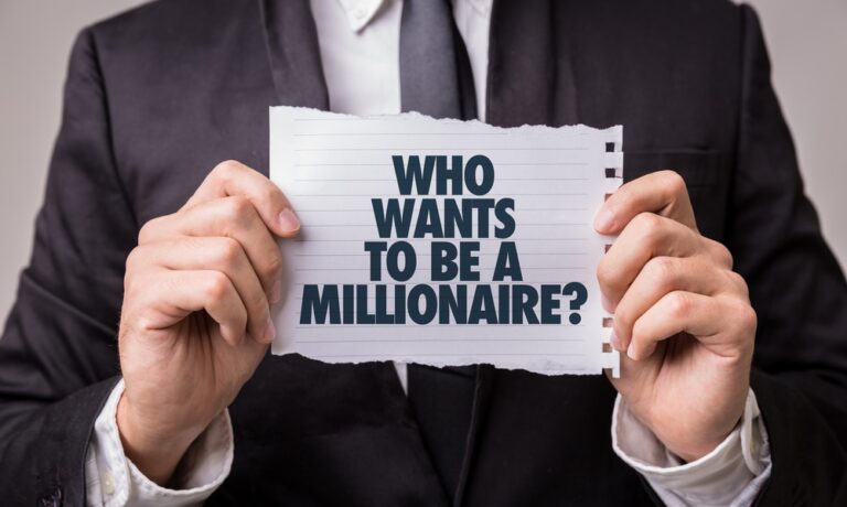 A person in a suit holds a piece of torn paper with the text WHO WANTS TO BE A MILLIONAIRE? printed in bold letters.