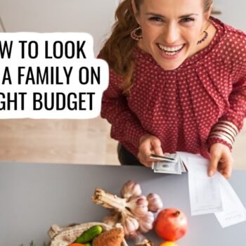 A smiling woman in a red blouse holds cash and receipts in a kitchen, standing near a counter with vegetables. Text reads: “How to look feed a family on a tight budget.”.