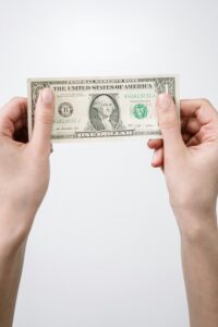 Close-up of hands holding a one dollar bill, symbolizing finance and currency.