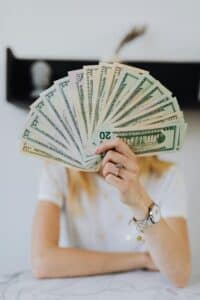 A person holding a fan of US dollar bills, symbolizing wealth and financial success.
