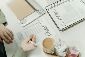 A professional organizing the week with detailed schedule planners in an office setting.