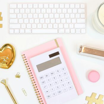 Flat lay of stylish office supplies arranged on a white background, showcasing a feminine workspace.