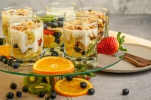 Delicious yogurt parfaits with fresh fruits and granola on a modern platter.
