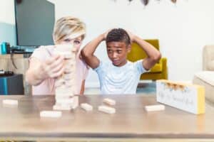 A mother and son share a fun bonding moment playing Jenga indoors.