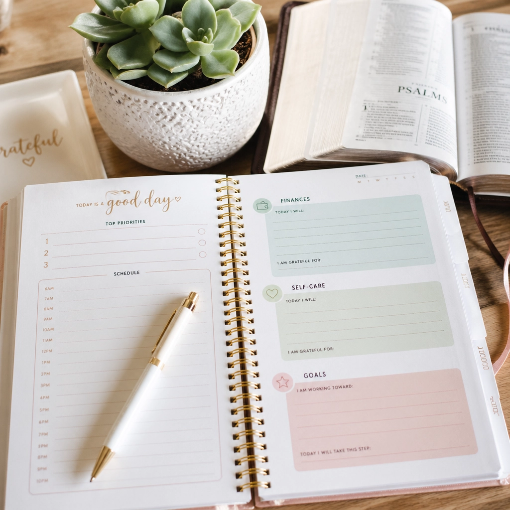 A beautiful daily planner on a desk with a Bible and greenery, highlighting the balance of life and spirit.
