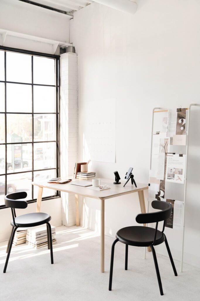 A light airy work space with a desk and two chairs.