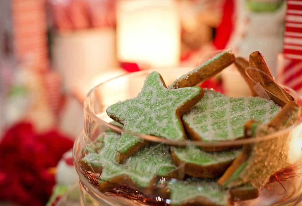 Close-up of festive green frosted Christmas cookies in a decorative jar, perfect for holiday celebrations.