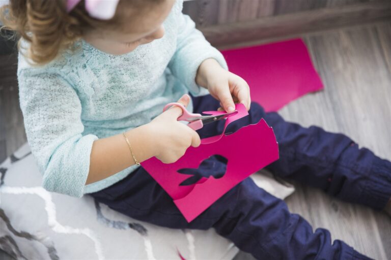 Easy paper crafts for kids - girl cutting paper rabbit shapes with scissors